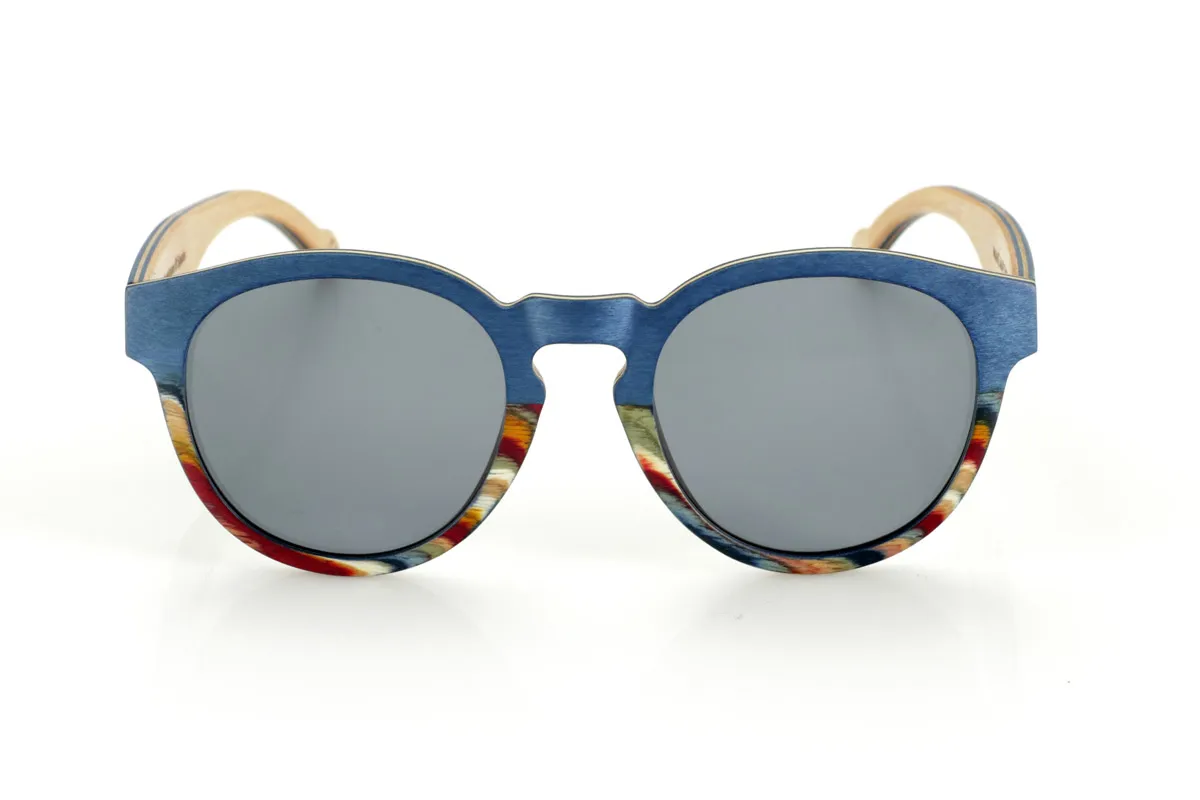 Wood eyewear of Maple WANZ. WANZ sunglasses are made from a combination of laminated woods that provide a unique and distinctive style. Its blue maple wood front merges with a multicoloured rainbow skateboard sheet, creating a dynamic and original visual effect. The temples, made from blue tinted maple with a natural maple wood interior, complement the design with a balance between modernity and warmth.

Thanks to their layered wood construction, these wooden sunglasses guarantee strength without compromising comfort. They incorporate high-quality polarised lenses that offer full UV protection and reduce glare, improving visual clarity.

A versatile model that stands out for its bold design and its inspiration from nature. Dimensions: 138x52mm. Caliber 49. for Wholesale & Retail | Root Sunglasses® 